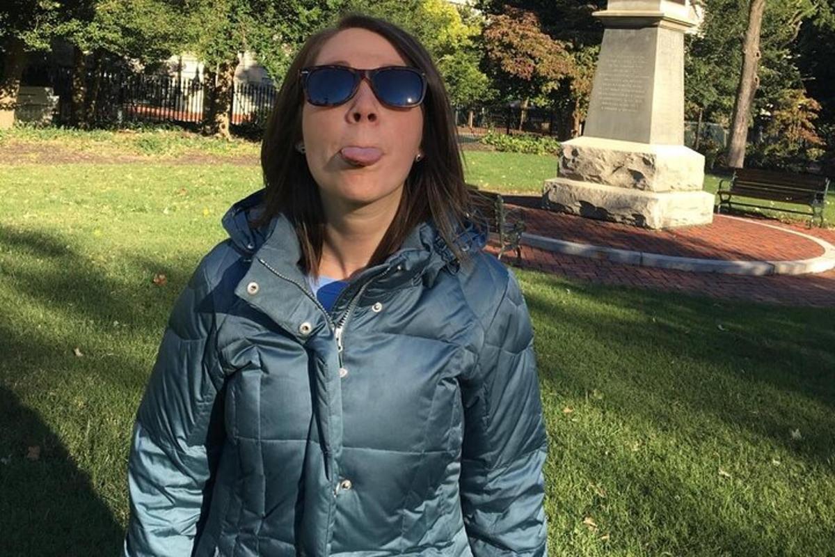 a woman in sunglasses standing in a park