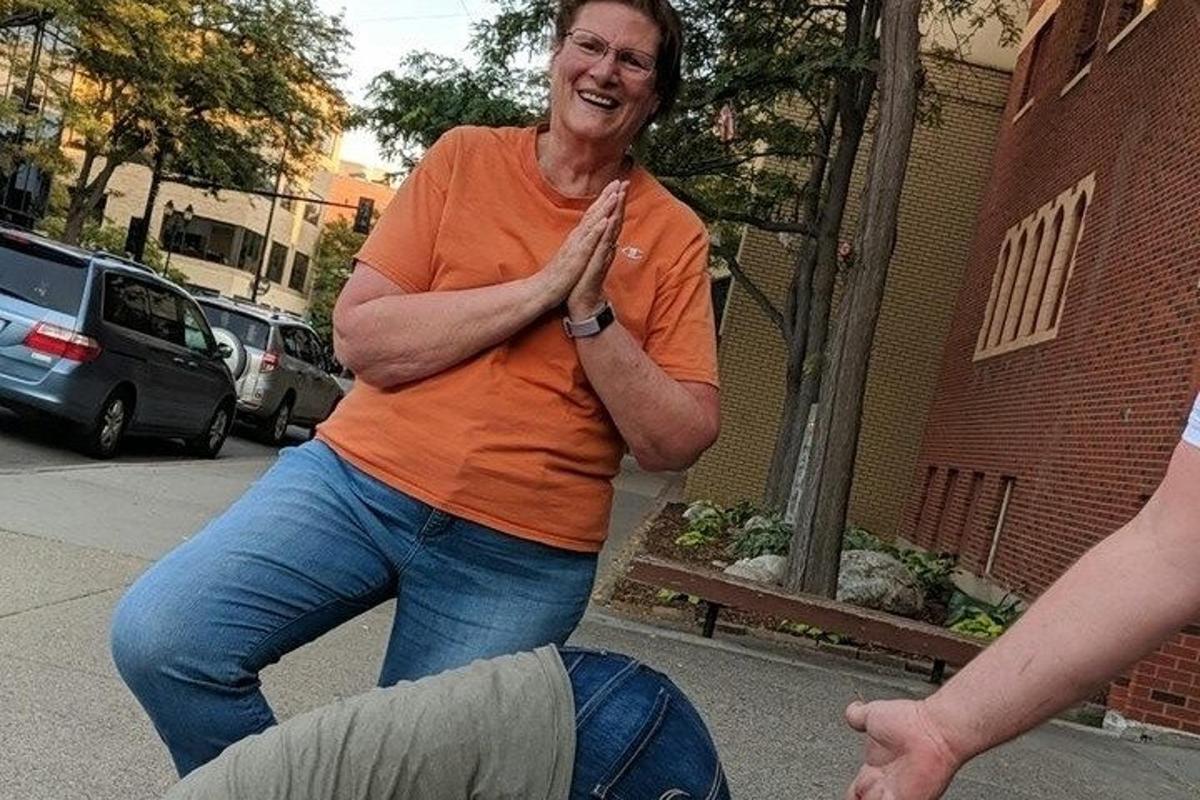 a man in an orange shirt standing on the street
