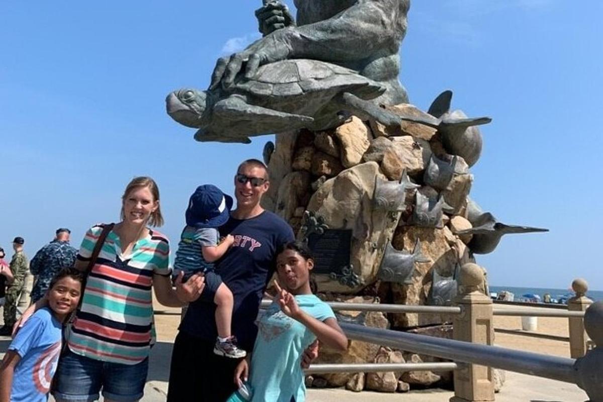 a family posing in front of a dinosaur statue