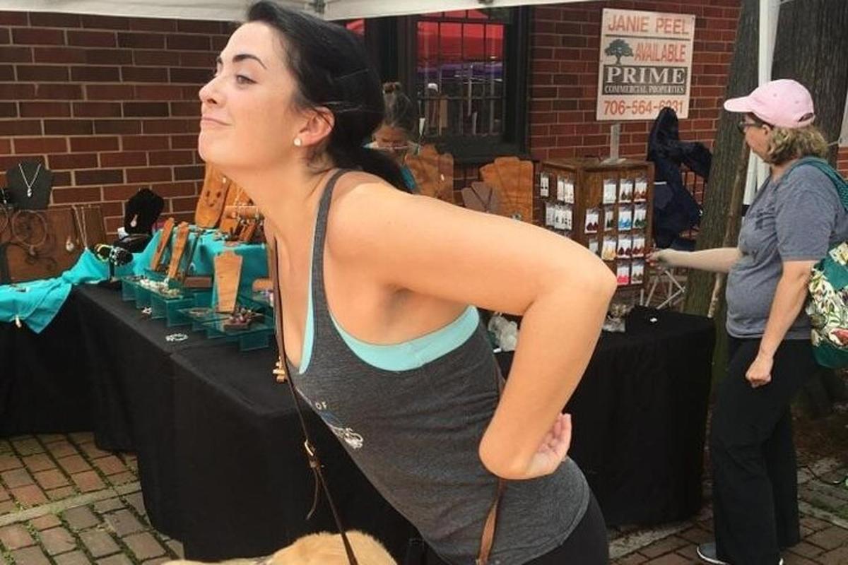 a woman standing next to a table with a dog