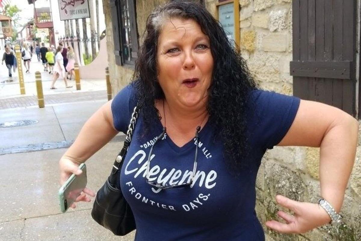 a woman standing on a street holding a cell phone