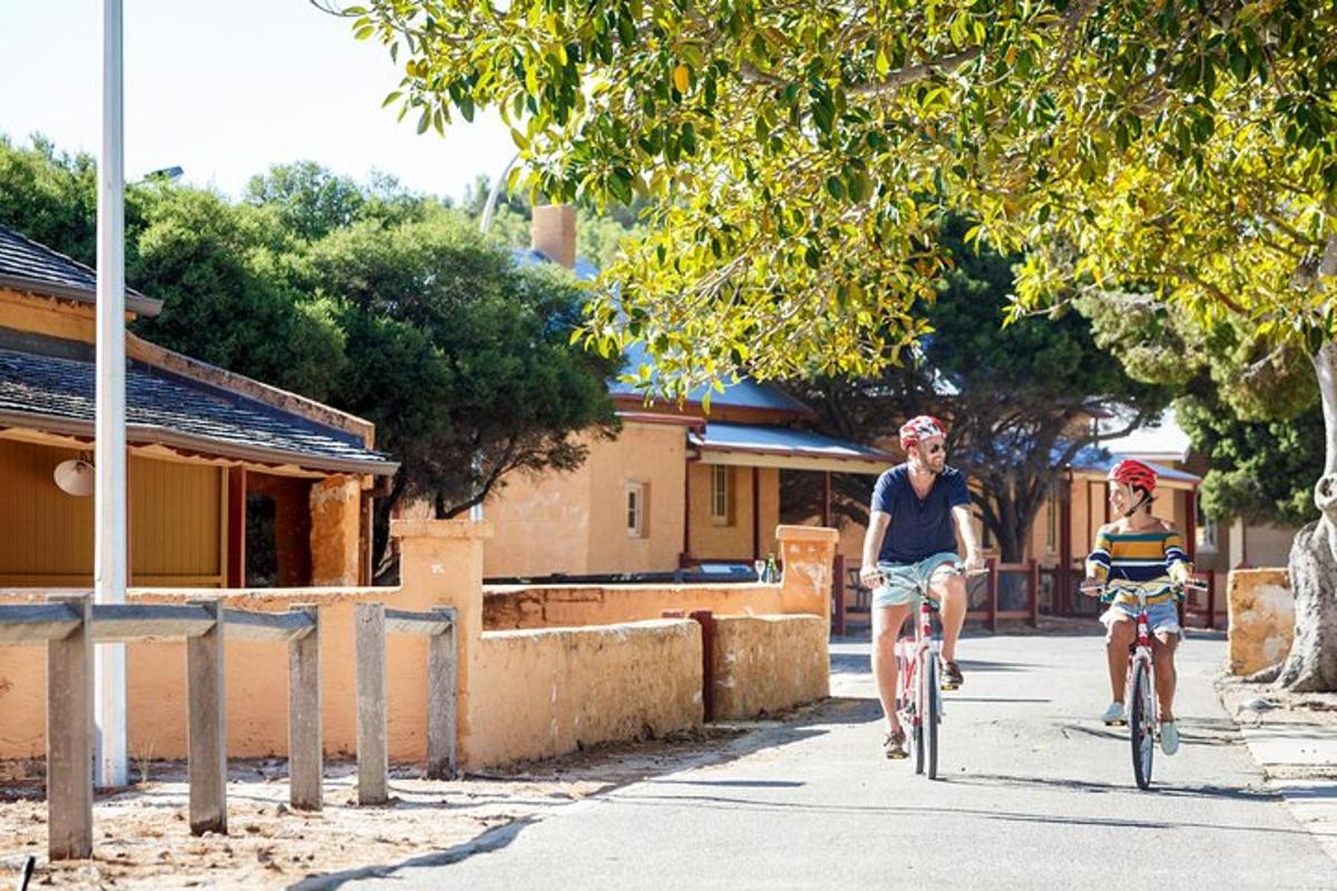 two people riding bikes down a street