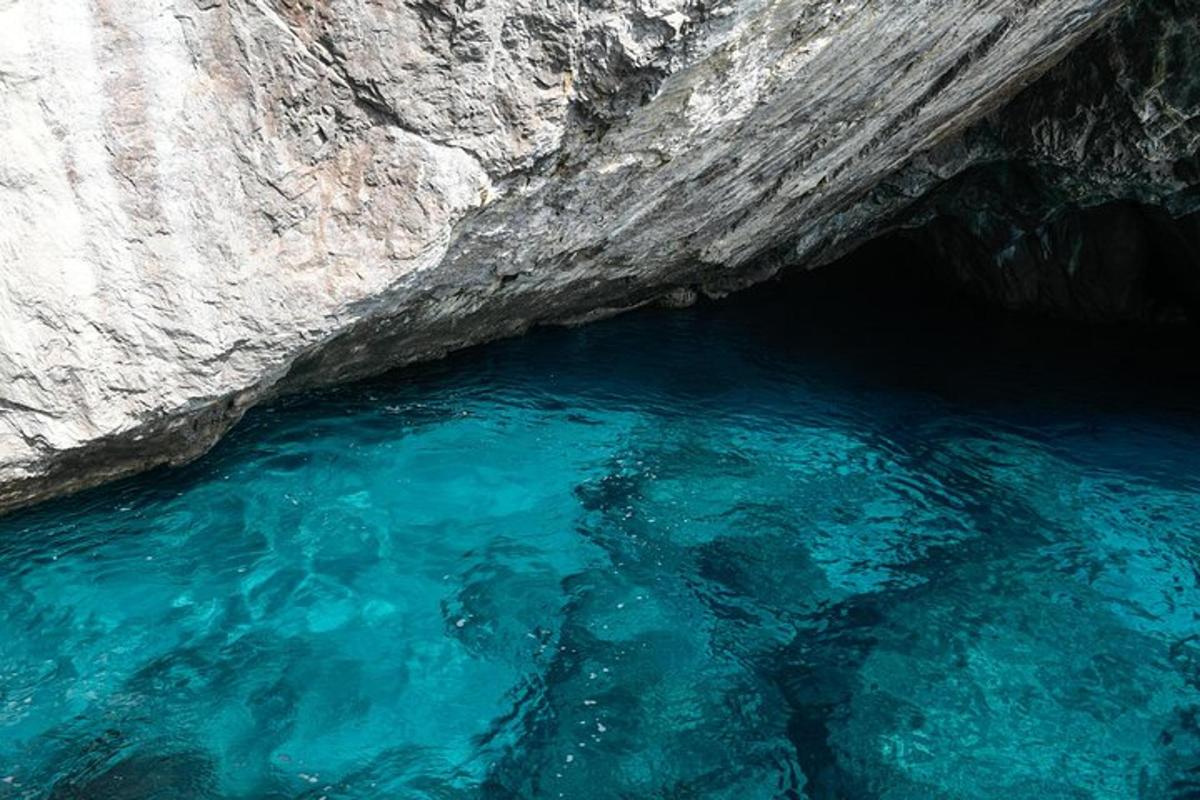 a pool of blue water next to a cliff