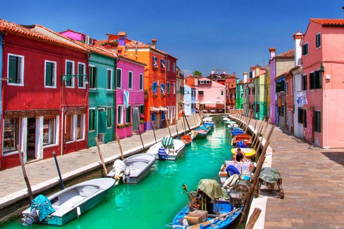 um grupo de barcos em um canal com edifícios coloridos