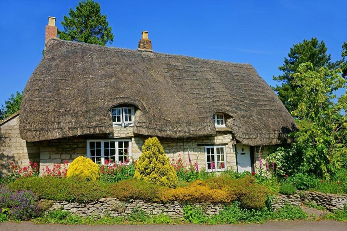 una piccola casa di pietra con il tetto di paglia