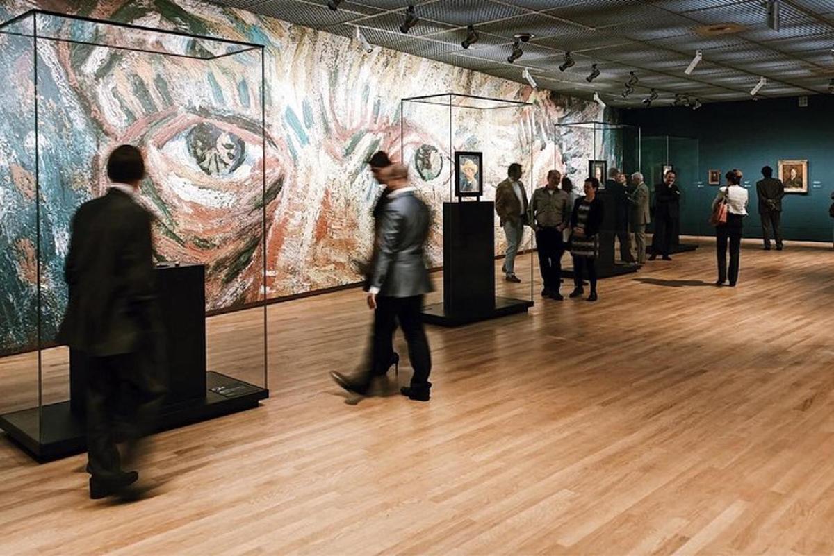 een groep mensen die naar een schilderij in een museum kijkt