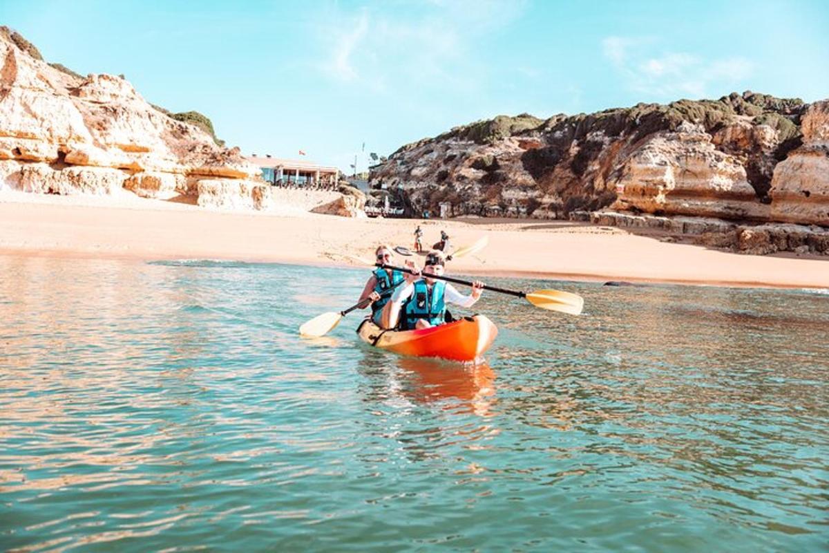duas pessoas em um caiaque na água perto de uma praia