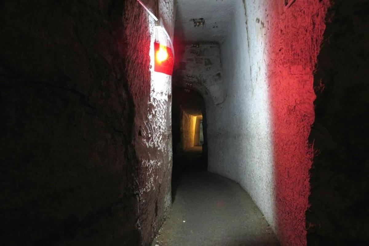 a dark hallway with a red and white wall
