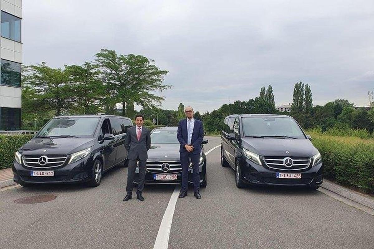 dua lelaki berdiri di tempat letak kereta di sebelah dua kereta
