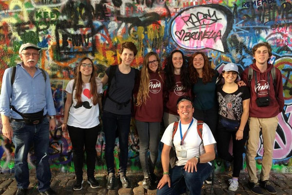 Un grupo de personas de pie frente a una pared con grafitis.