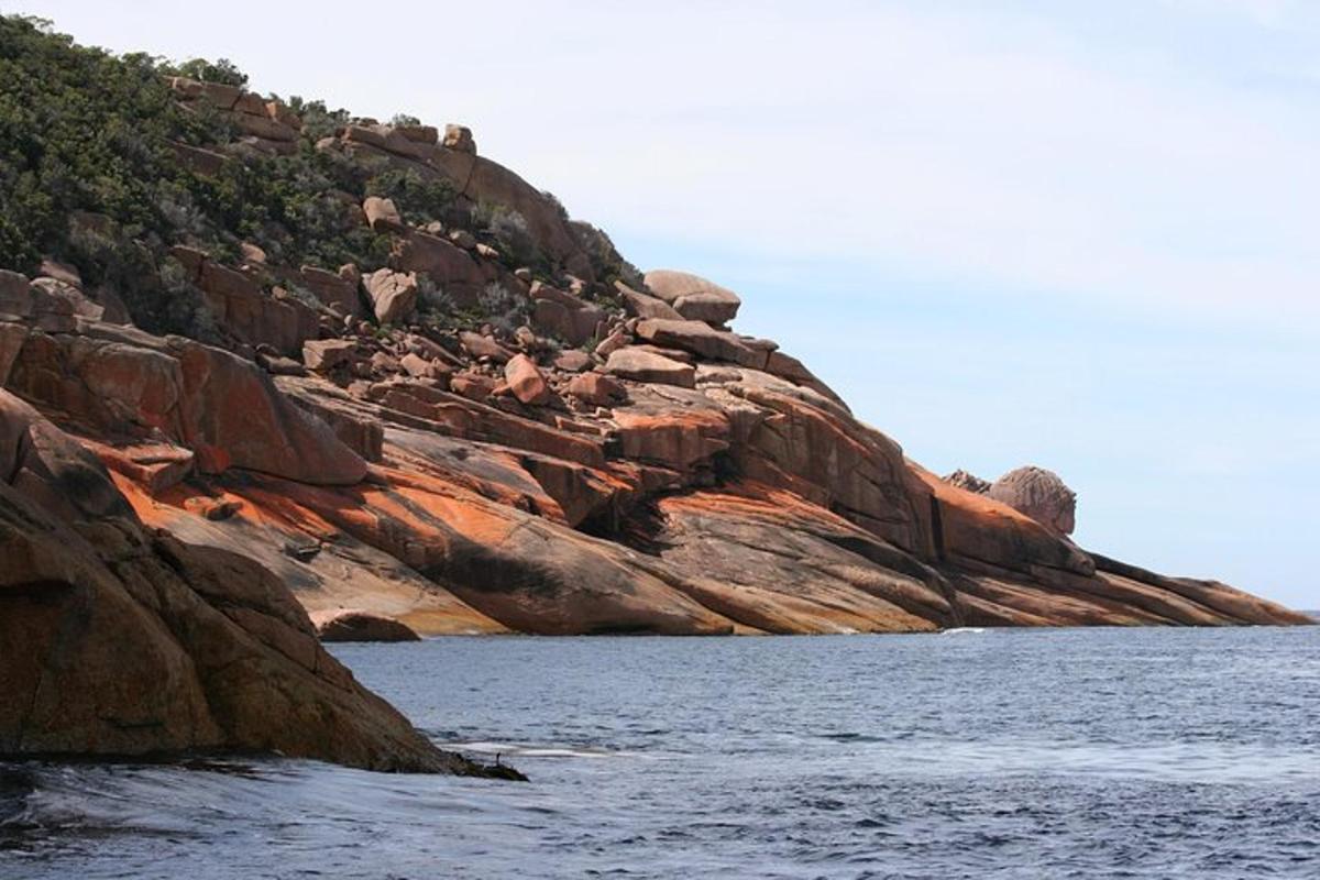 a rocky hillside next to a body of water