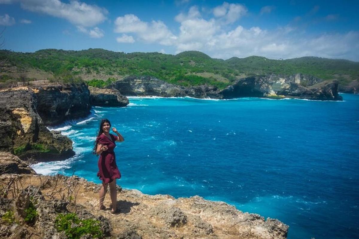 una donna in piedi su una scogliera che domina l'oceano