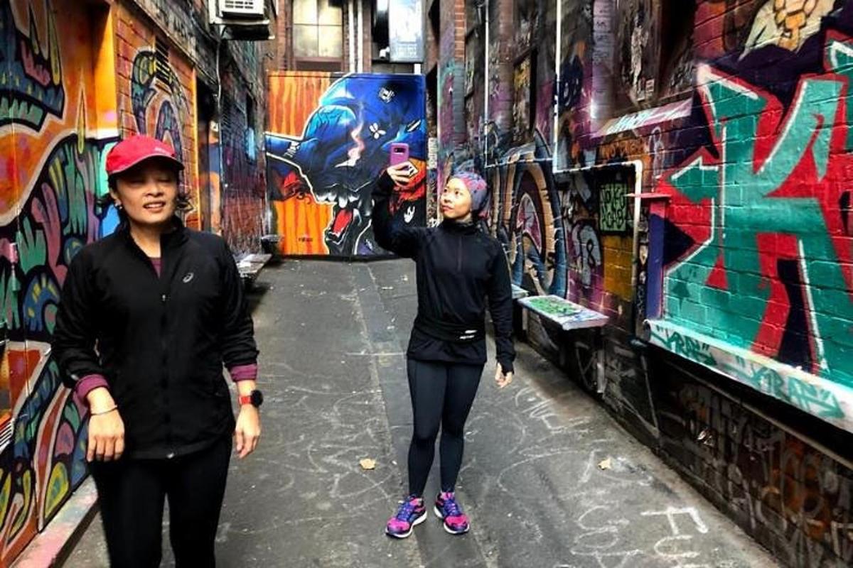 due donne in piedi in un vicolo con graffiti