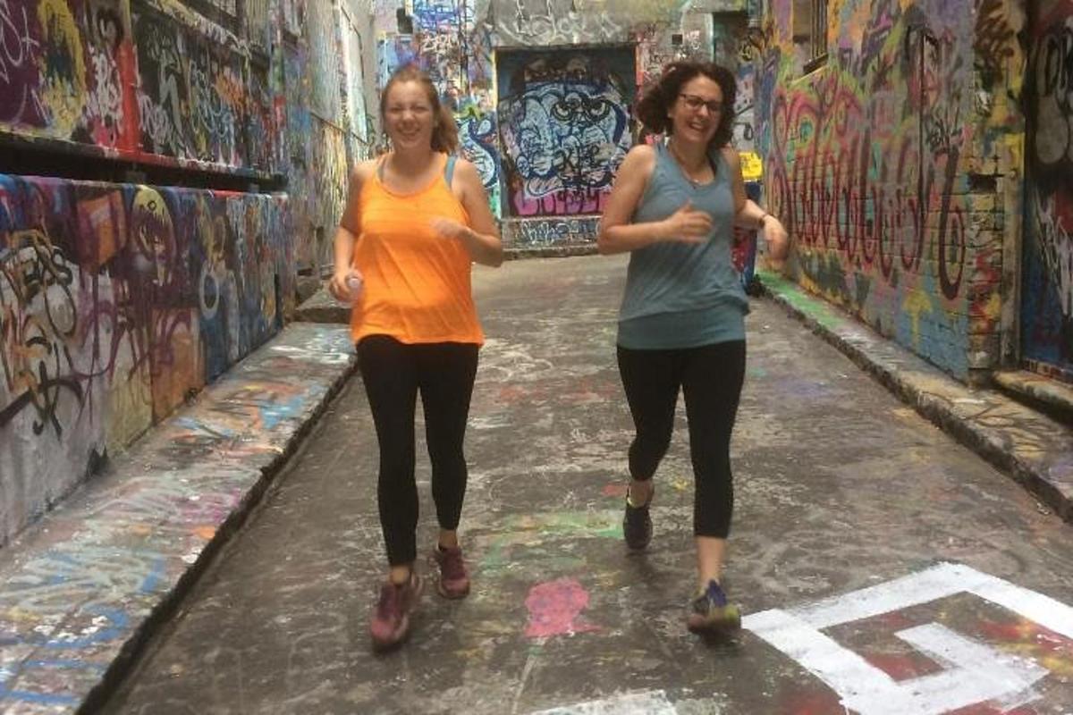 due donne che camminano in un vicolo con graffiti