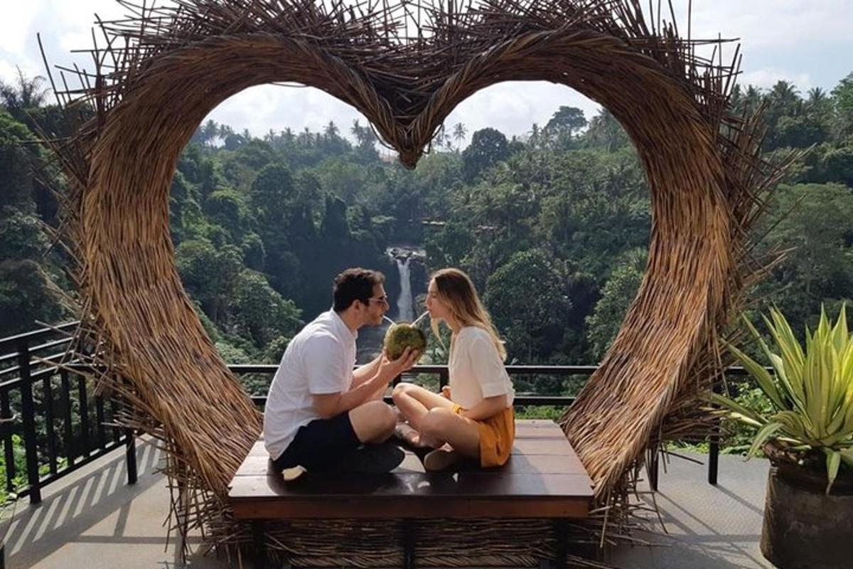 pasangan yang duduk di atas bangku di hadapan bentuk hati
