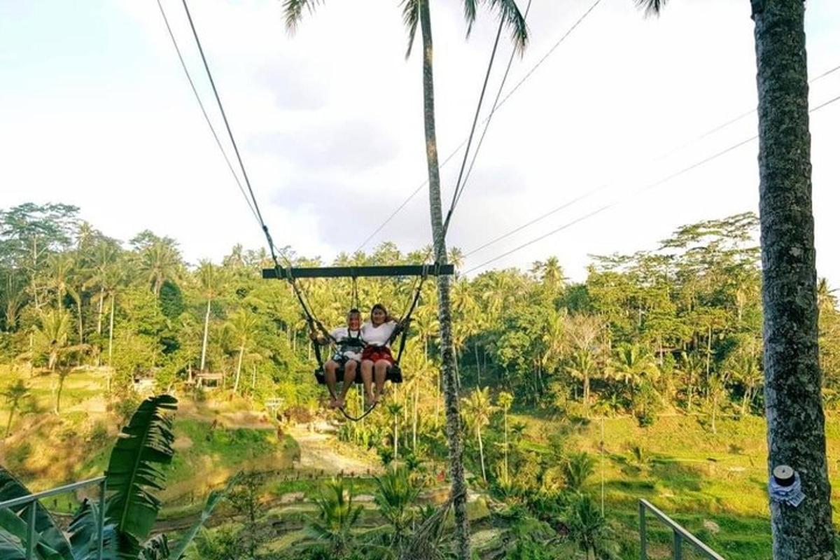 twee mensen rijden op een zipline in de jungle