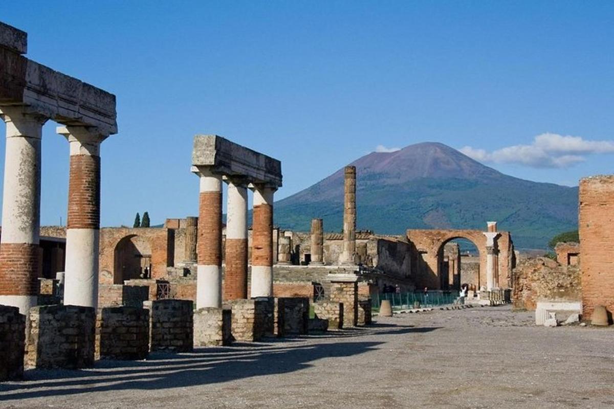 Una ciudad antigua con columnas y una montaña al fondo.