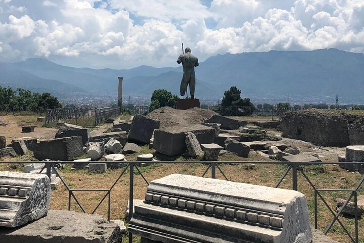 uma estátua de um homem em pé no topo de uma colina