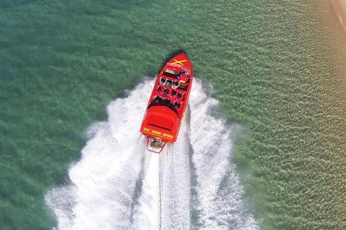a red boat in the water in the ocean