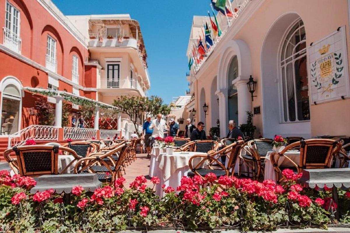 μια υπαίθρια καφετέρια με τραπέζια και καρέκλες και λουλούδια