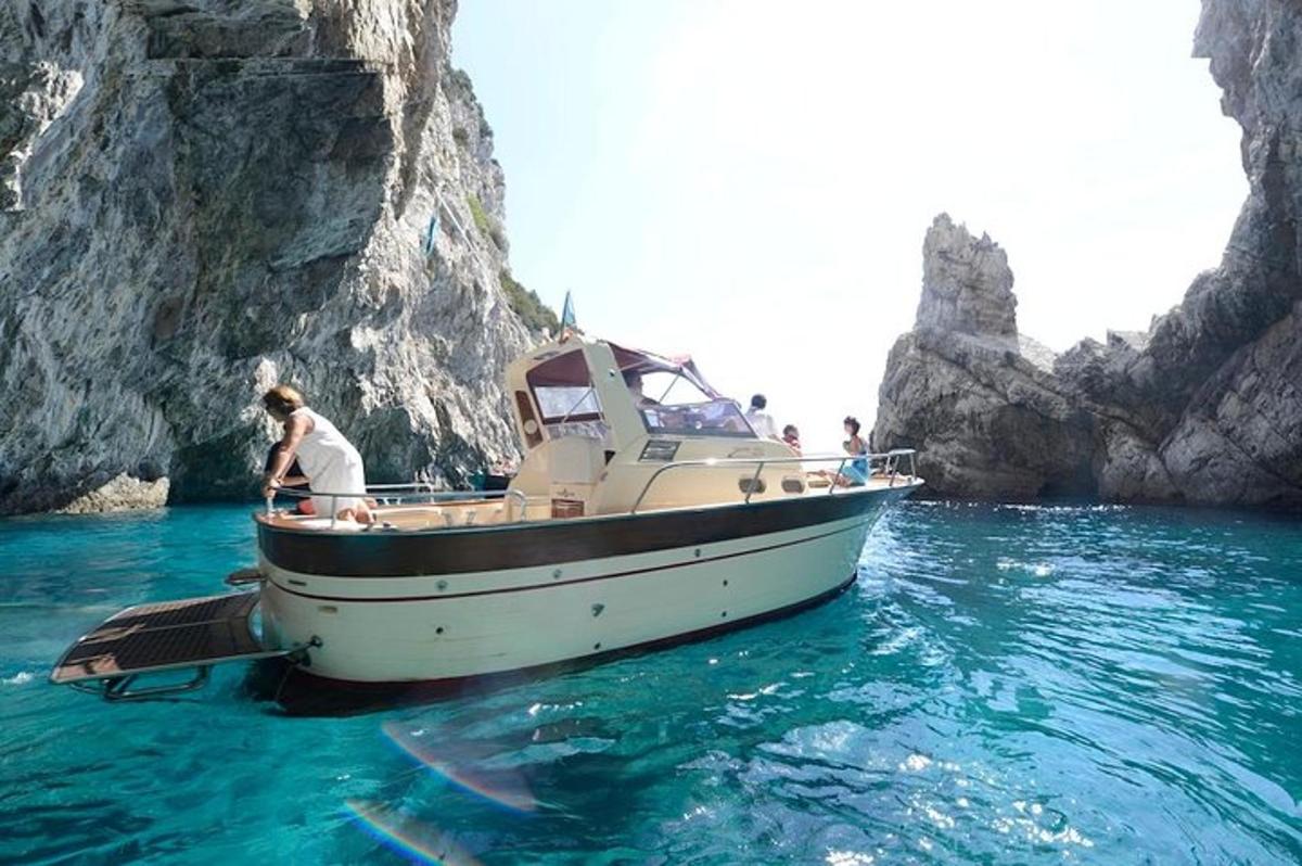 a boat in the water next to a rock formation