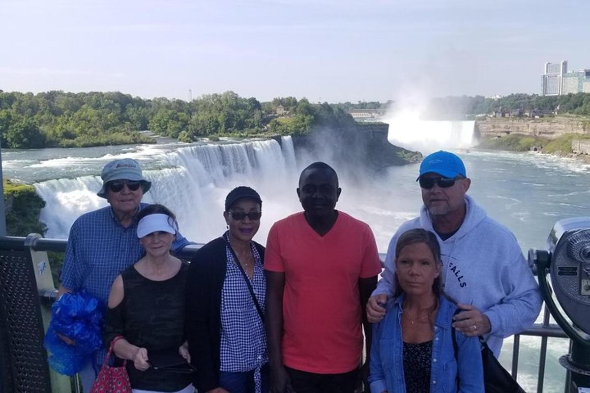 a group of people standing in front of a waterfall