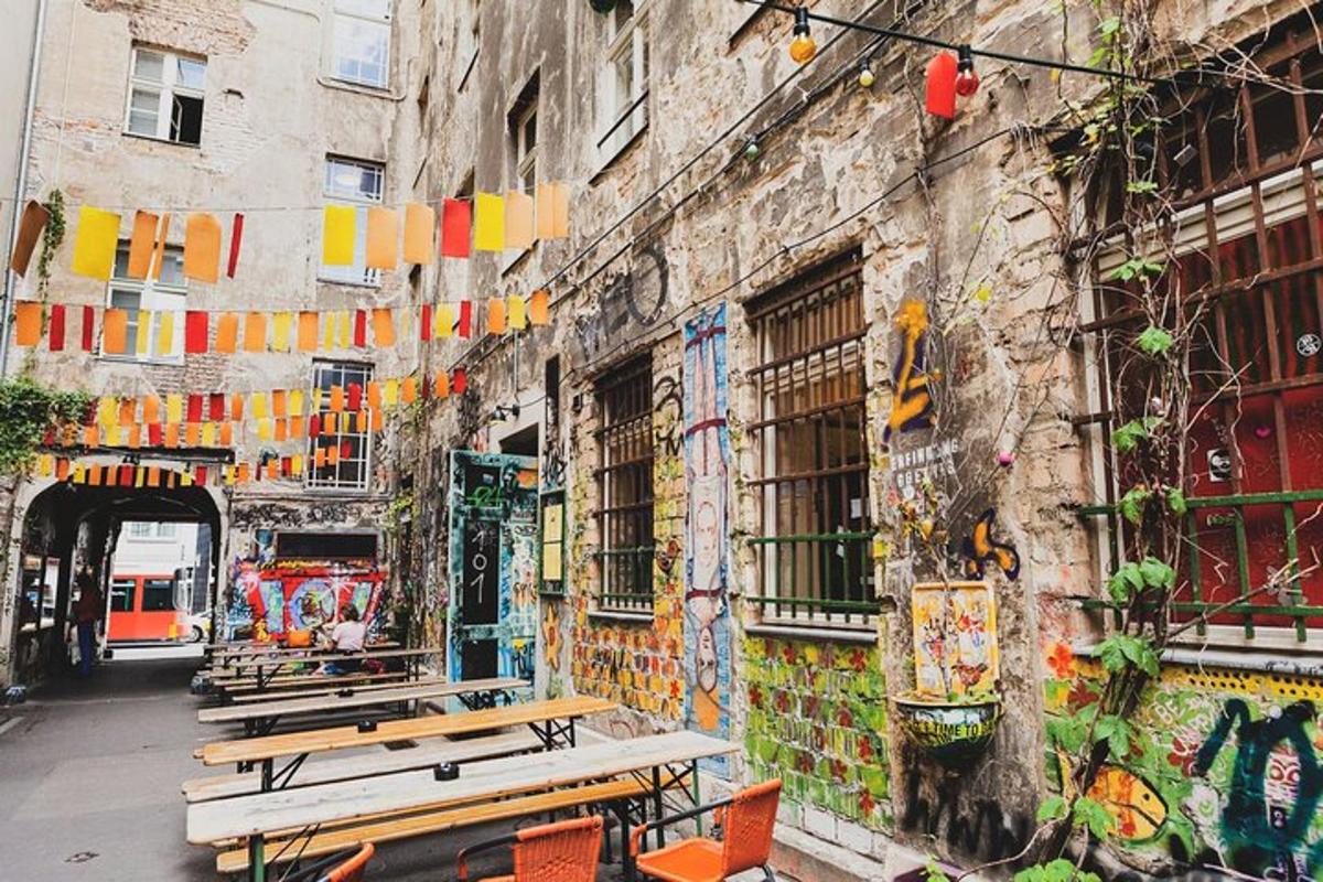 skupina laviček před budovou s graffiti