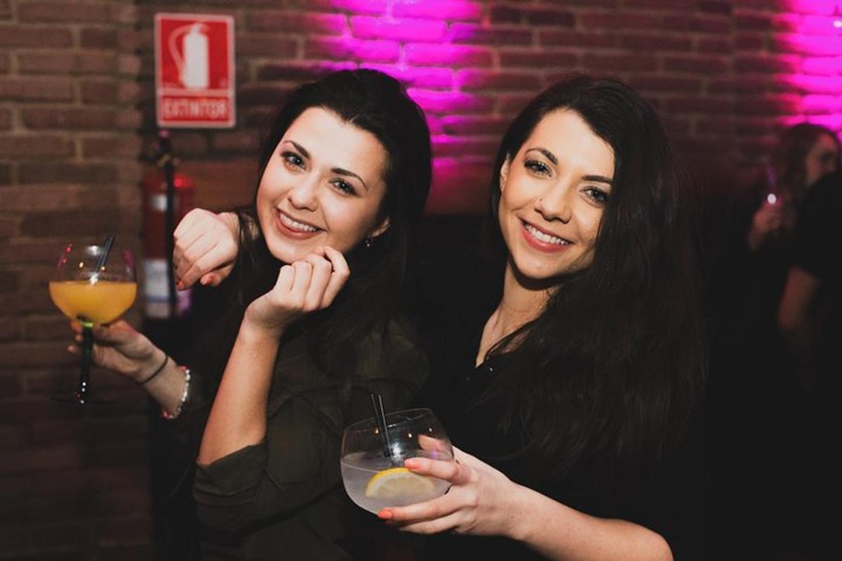 dve ženy držiace drink v bare