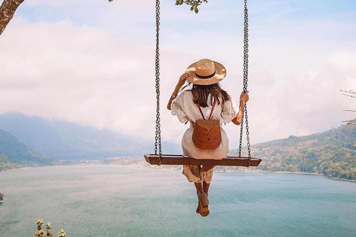 una mujer sentada en un columpio con vistas a un lago