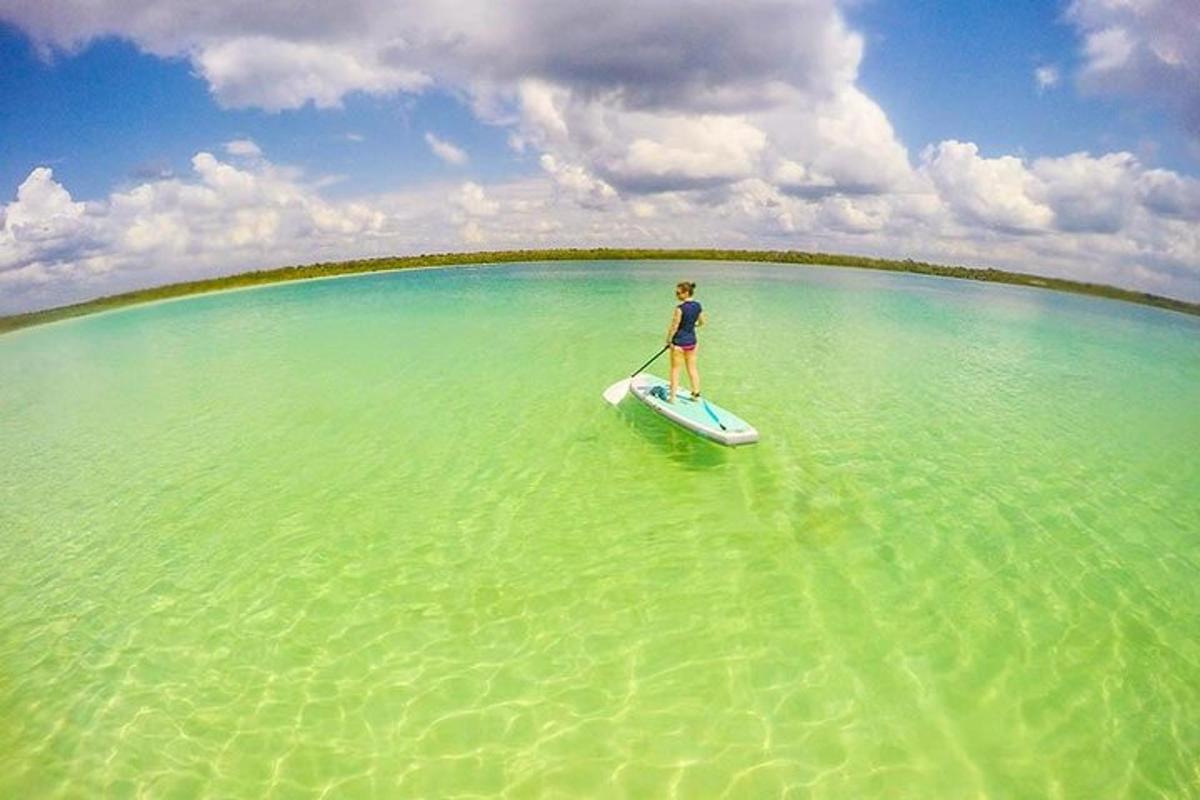un uomo in piedi su una tavola da paddle in acqua