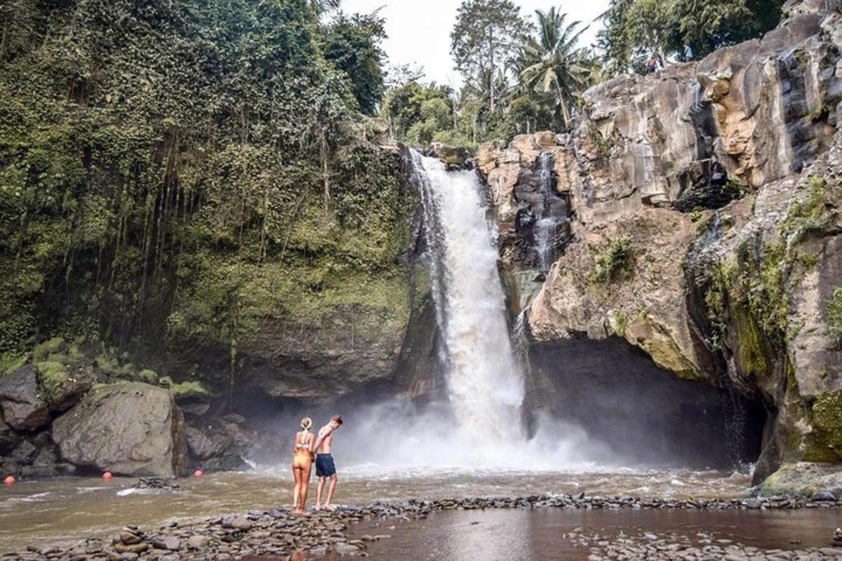 dos personas paradas frente a una cascada