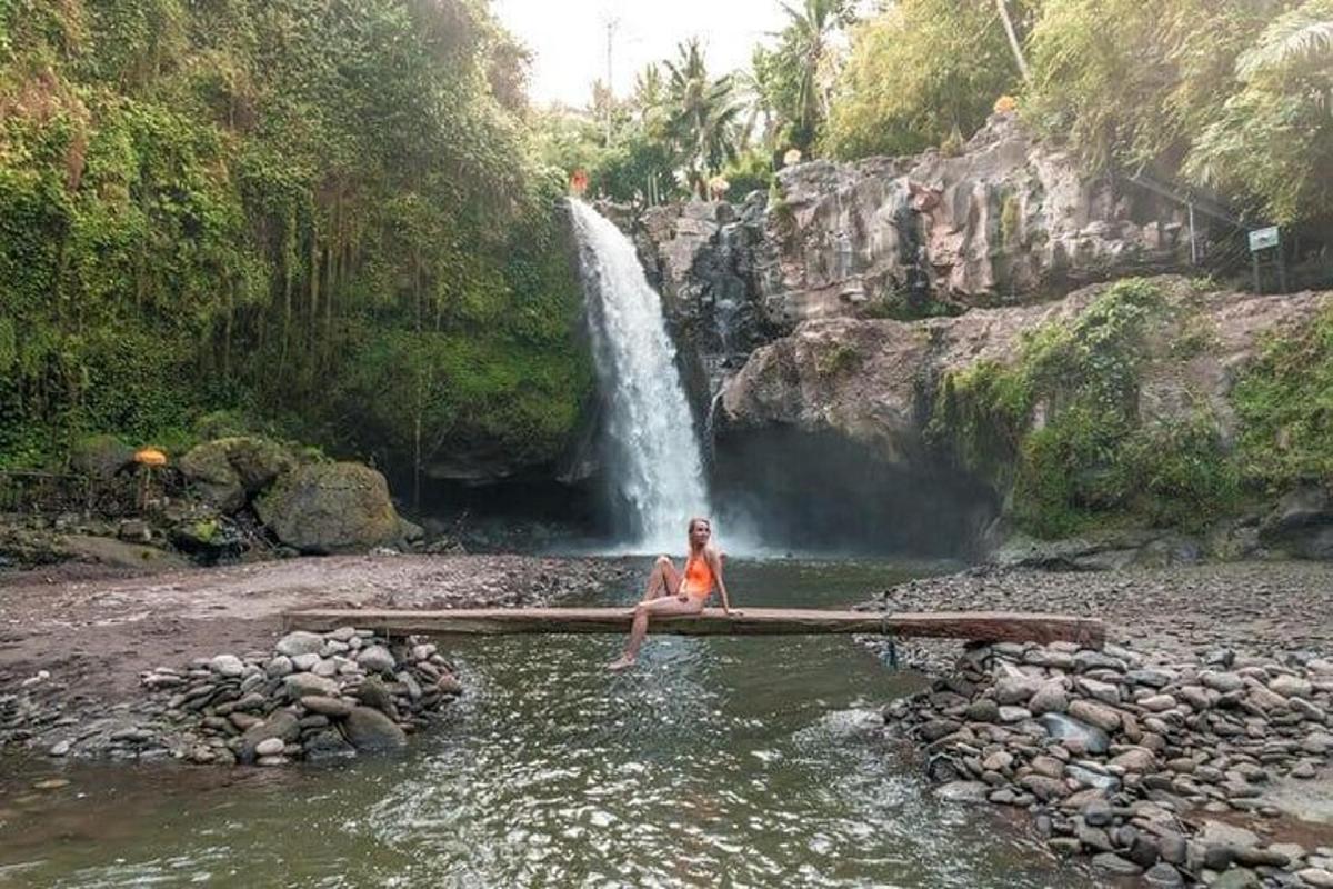 un uomo seduto nell'acqua di fronte a una cascata