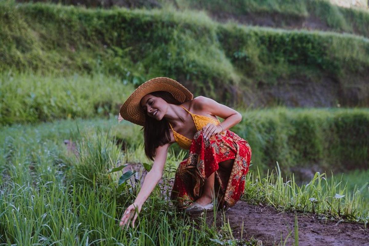 uma mulher com um chapéu de palha sentada em um campo