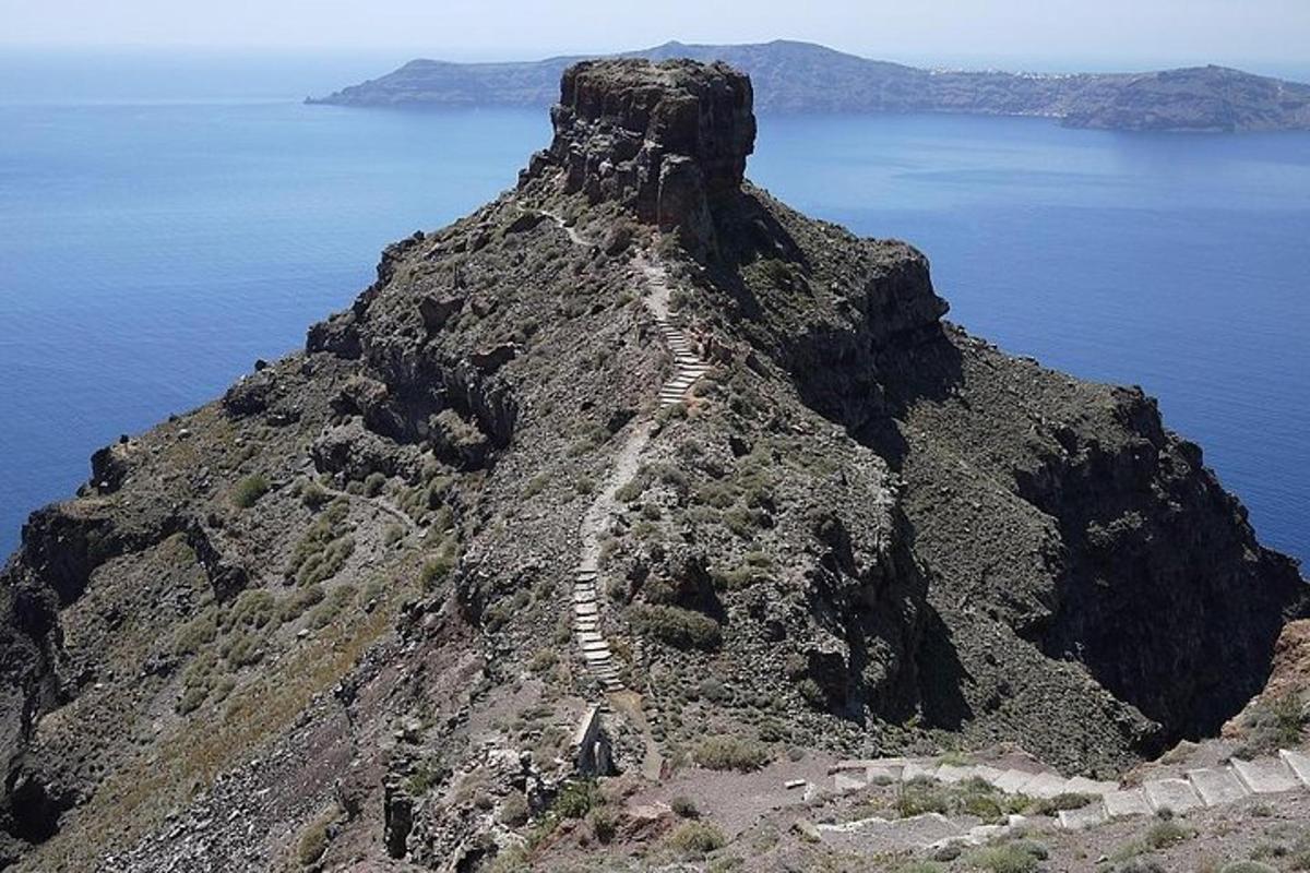 una montagna con un sentiero accanto all'oceano
