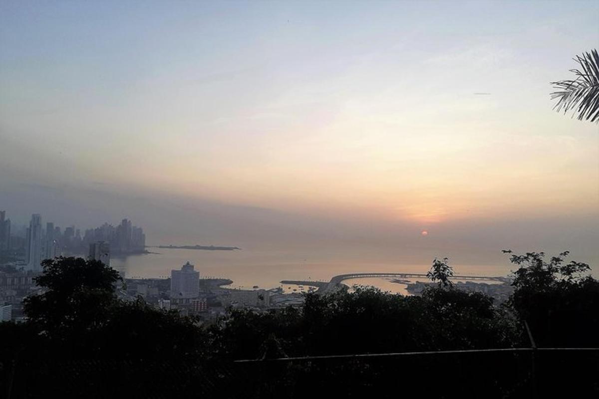 una vista di una città con il tramonto sullo sfondo