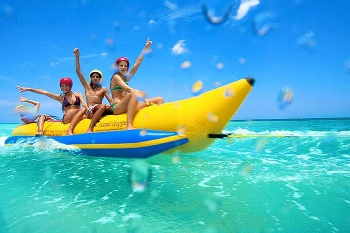 tre ragazze sedute su una banana boat nell'oceano