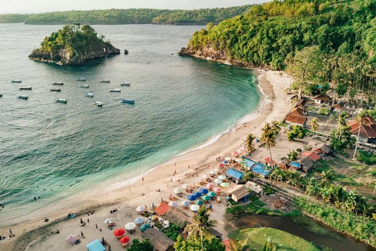 an aerial view of a beach with umbrellas and boats