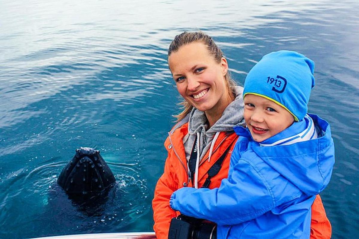 a woman and a child in the water with a whale