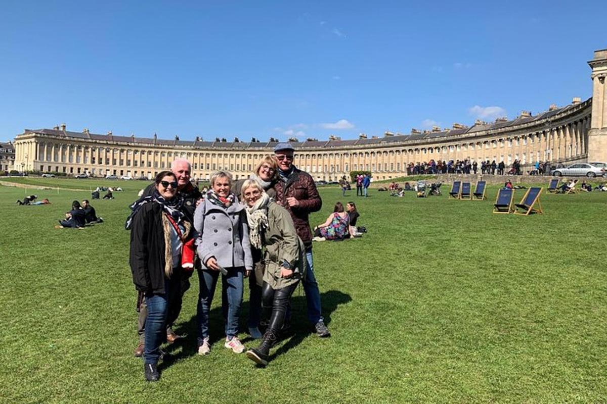 a group of people standing in the grass in front of a building