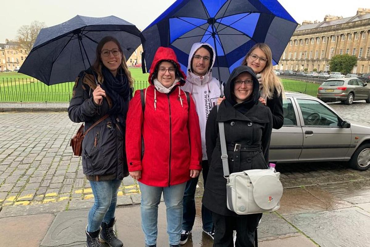 a group of people standing in the rain with umbrellas