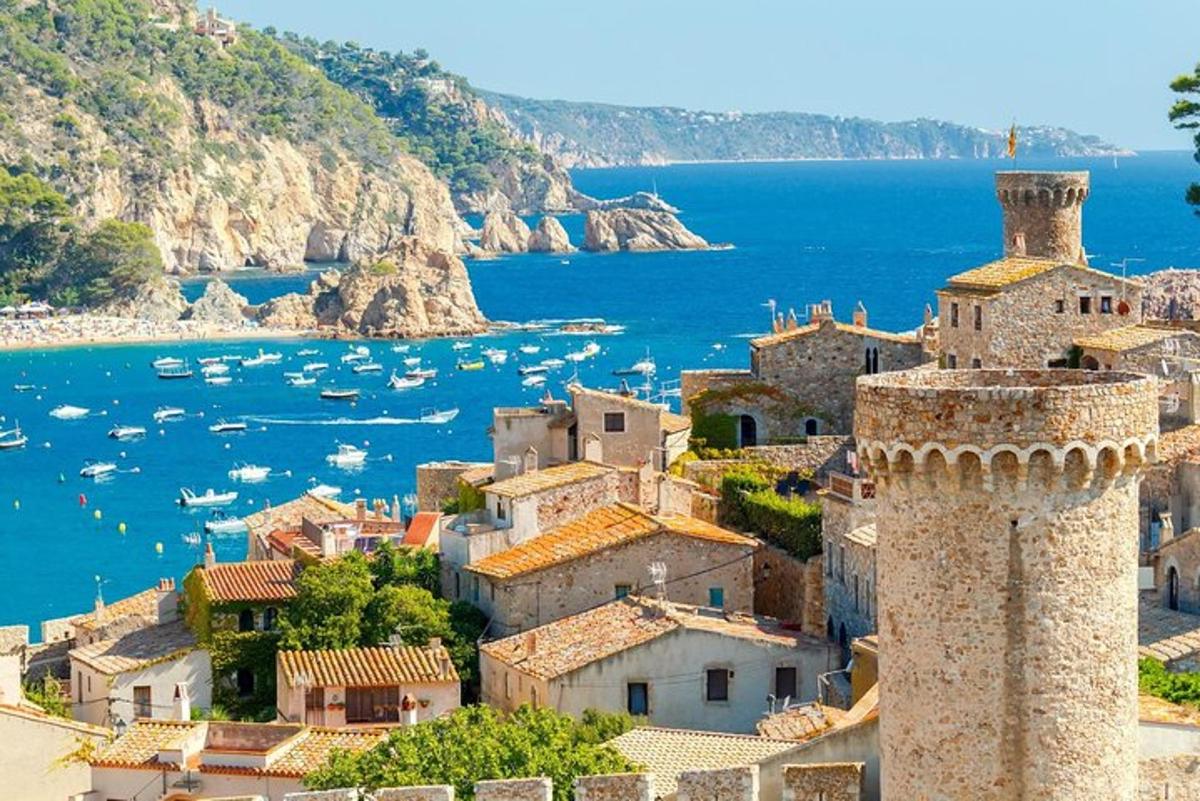 Una vista de un pueblo con una torre junto al agua.