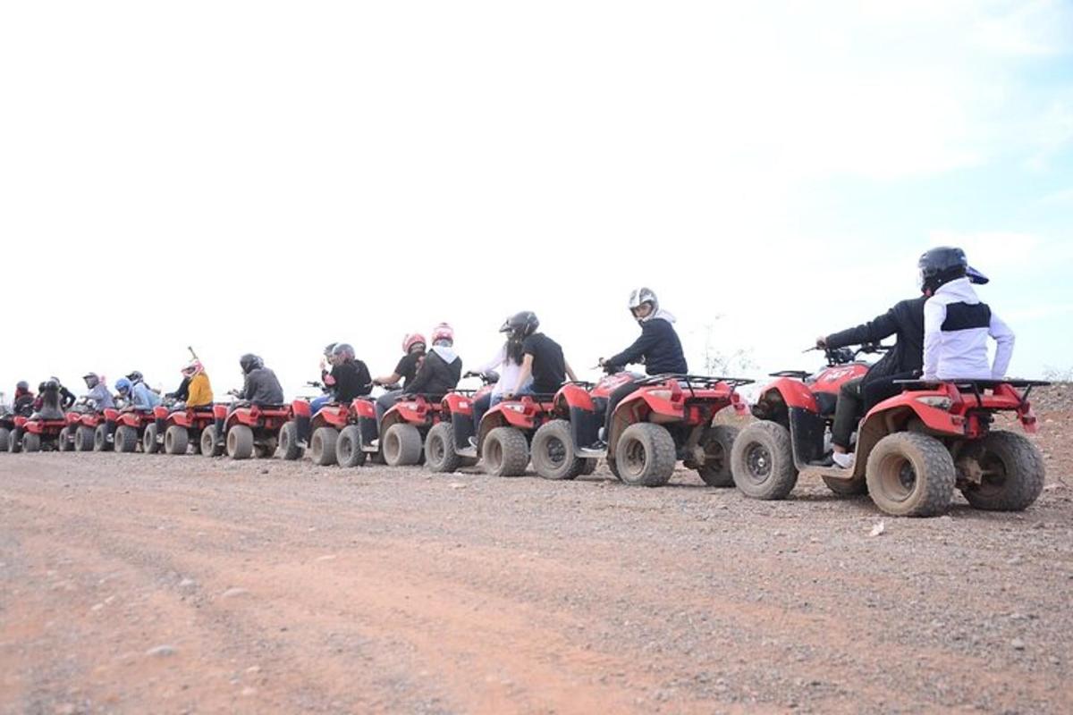a group of people riding atvs on a dirt road