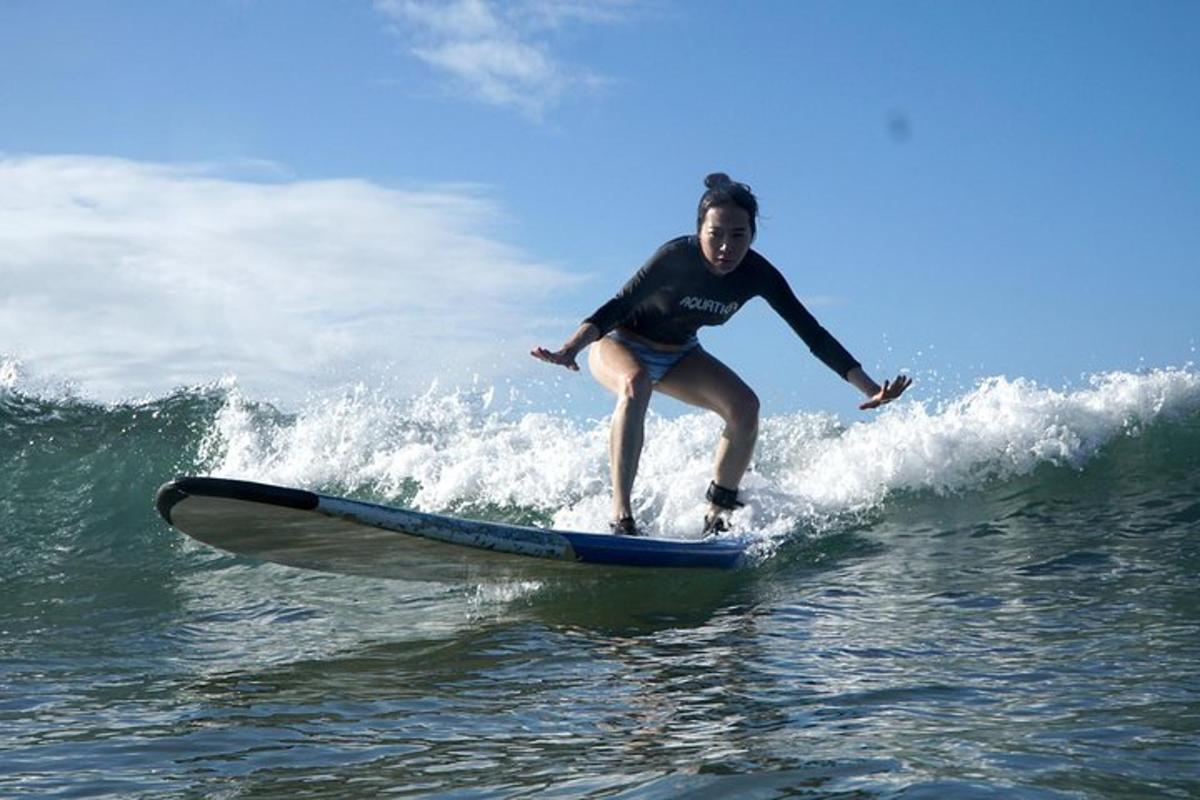 een vrouw die op een surfplank op een golf in de oceaan rijdt