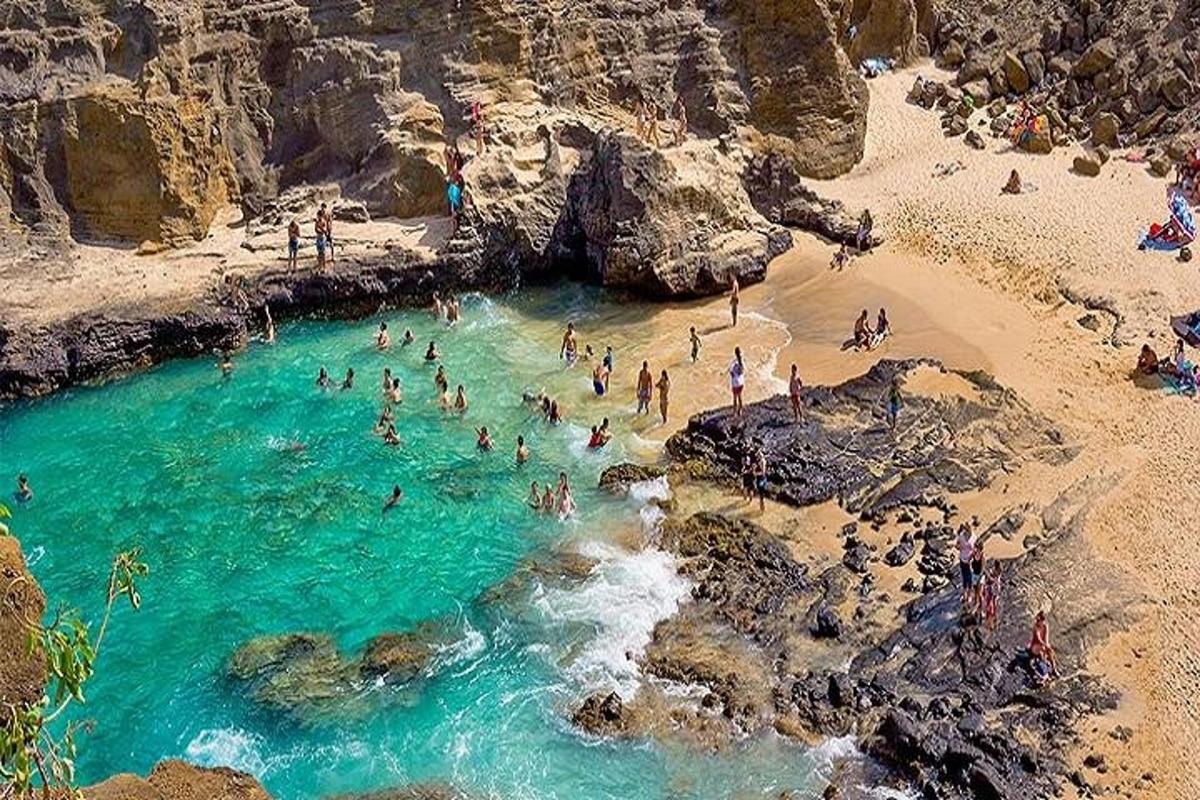 sekumpulan orang di dalam air di pantai