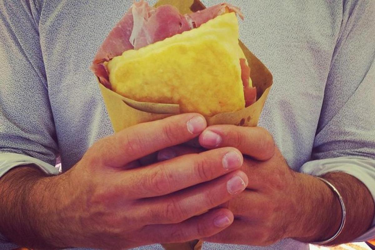 un uomo che tiene un pezzo di cibo tra le mani
