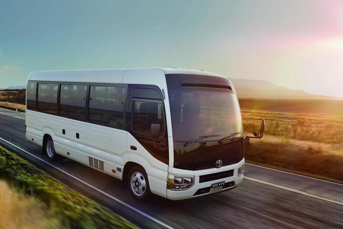 bílý autobus jedoucí po dálnici