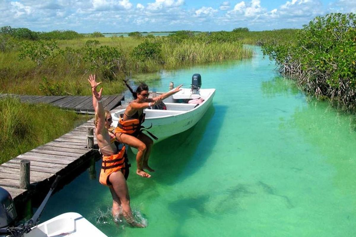 Dos personas saltando de un bote en el agua