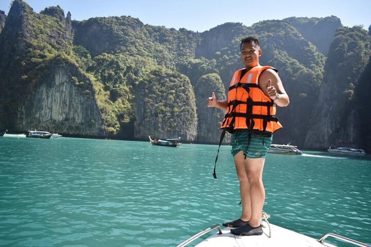 a man in an orange life vest standing on a boat in the water