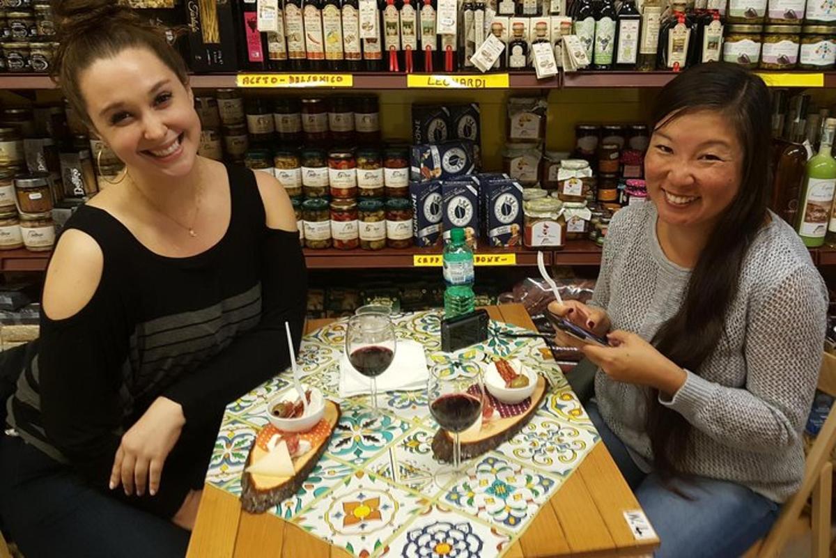 Dos mujeres sentadas en una mesa con copas de vino