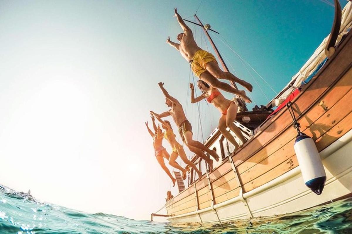 a group of men jumping off the side of a boat